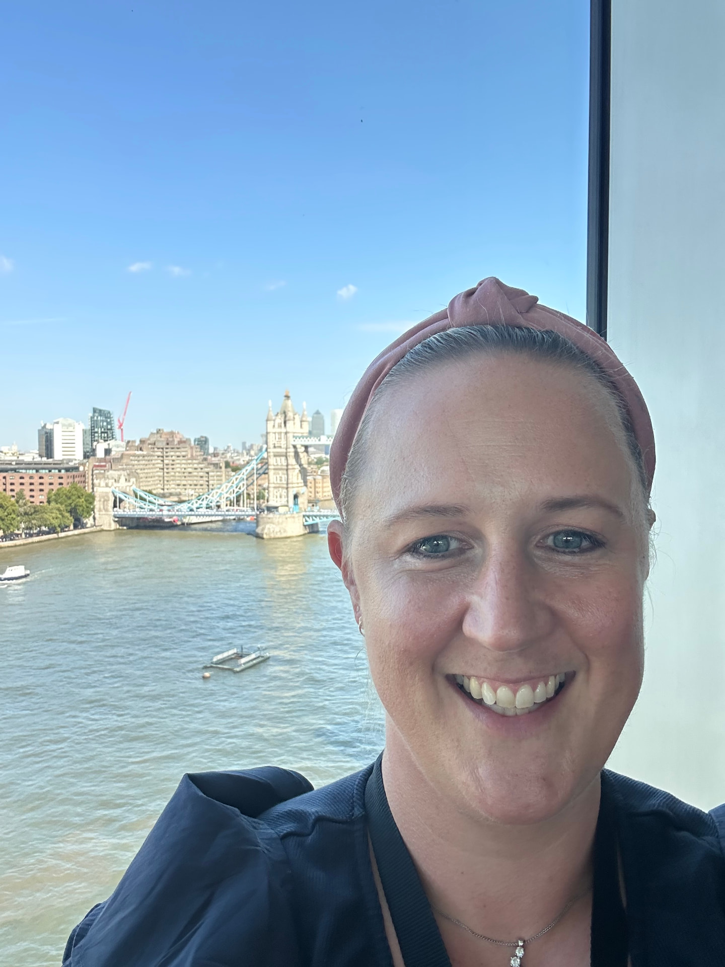 Susie Burns, founder of The Momentum Match, smiling with Tower Bridge and the Thames behind her